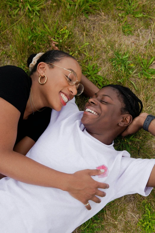 a couple laying on the ground together smiling