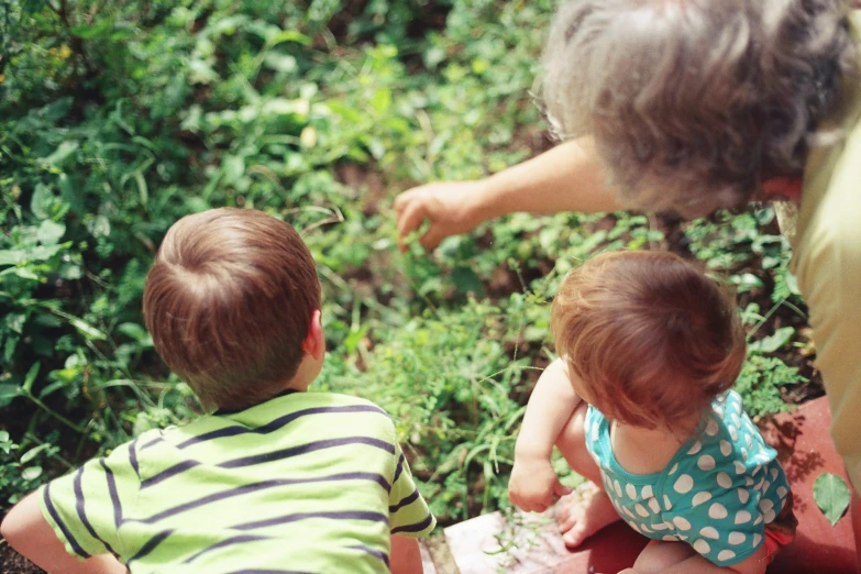 a group of children sitting in the dirt