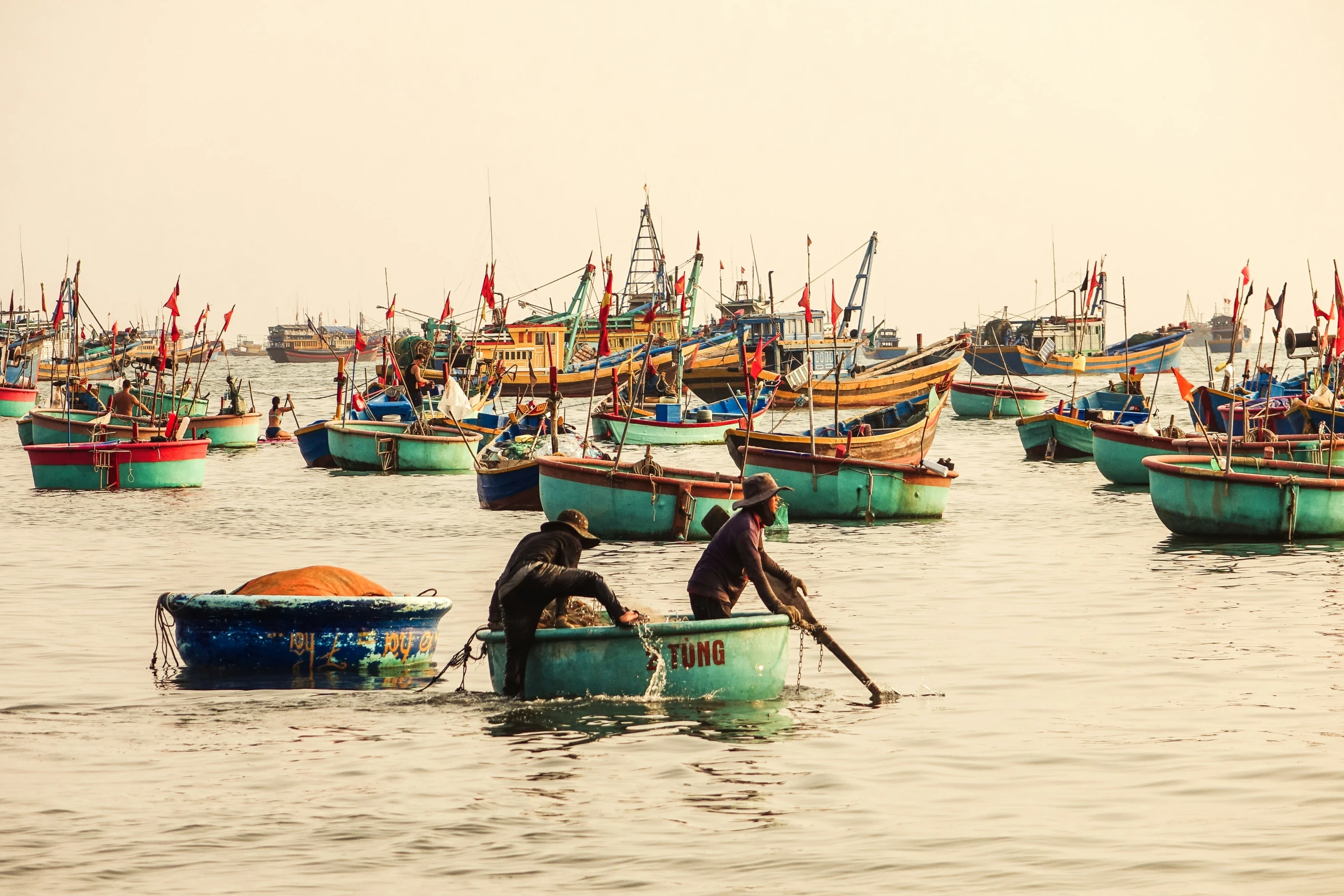 several men sitting in small boats on the water