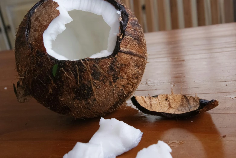 an open and partially eaten coconut on a wooden table