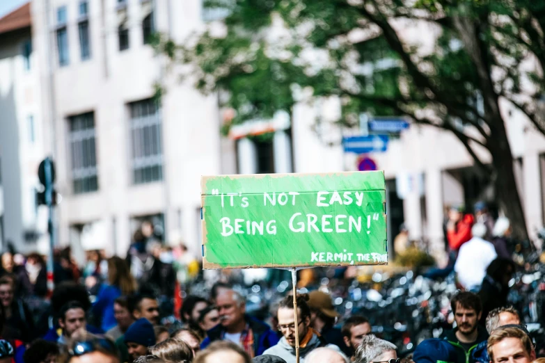 a crowd of people holding a sign with words written on it