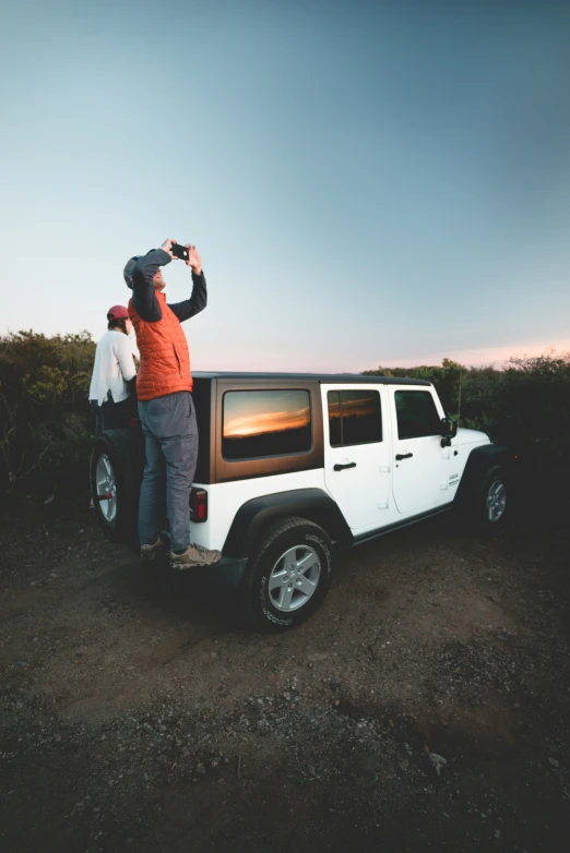 two people standing near a white truck