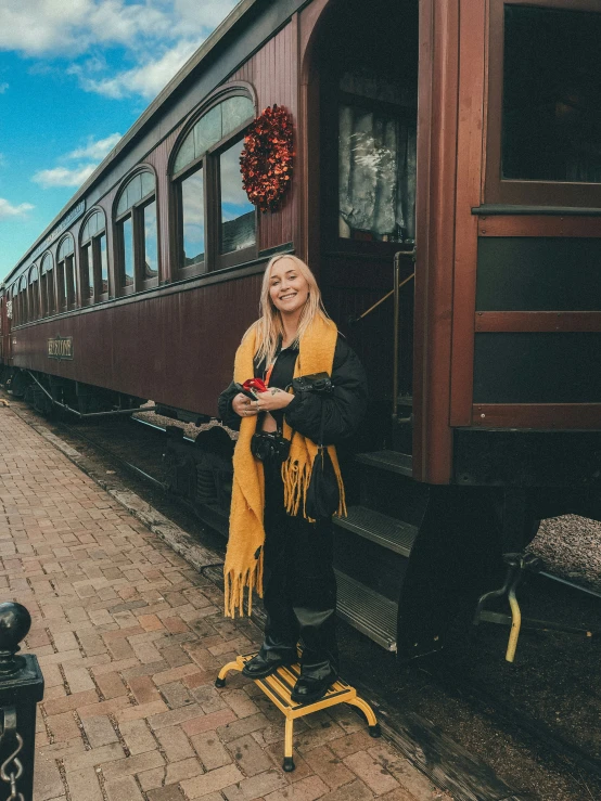 a woman wearing yellow in front of a train