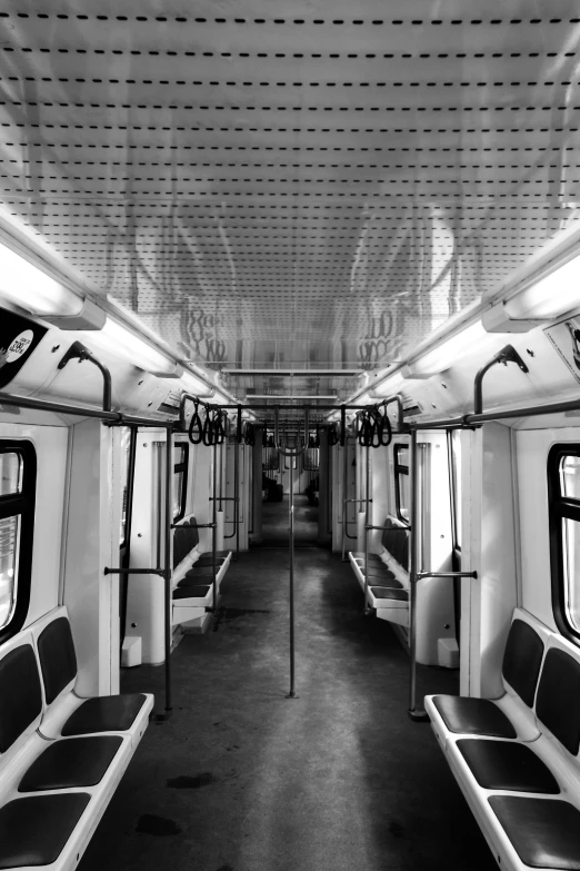 a monorail train car with some seats and railings