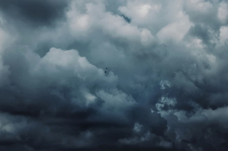 airplane flying through storm clouds over a body of water