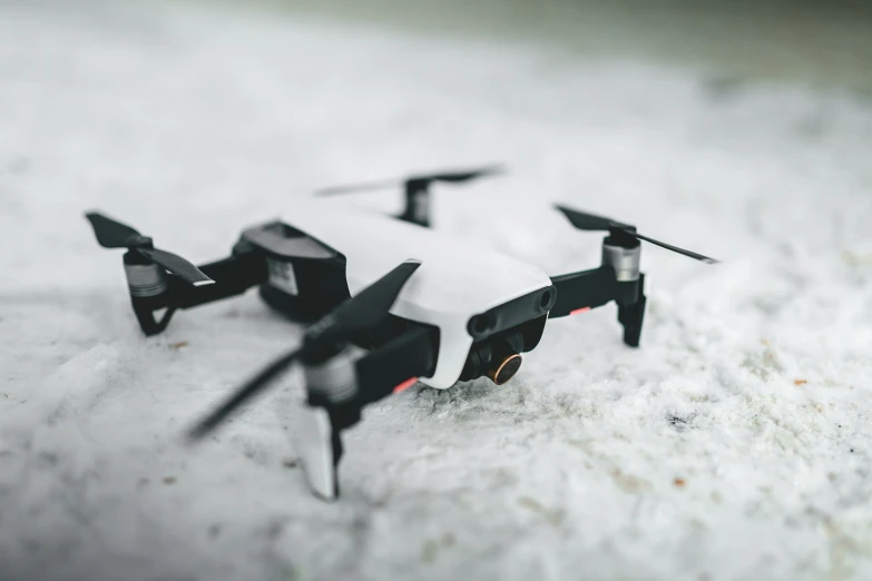 four small black plastic objects sitting on a snow covered surface