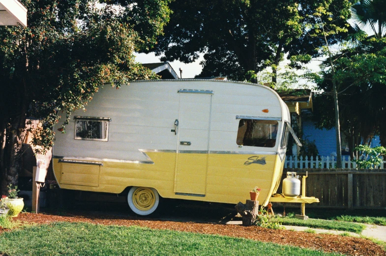 an old style camper trailer is parked on a lawn