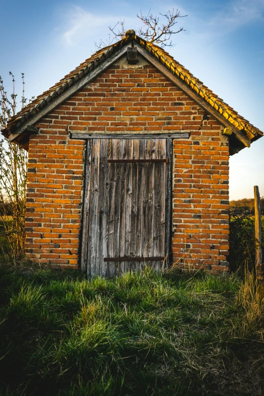 an old red brick barn with a door