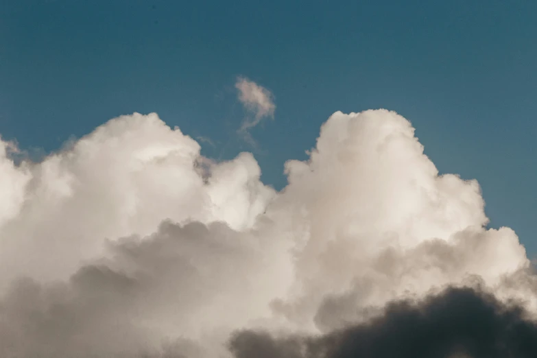 an airplane flies high through a cloudy sky