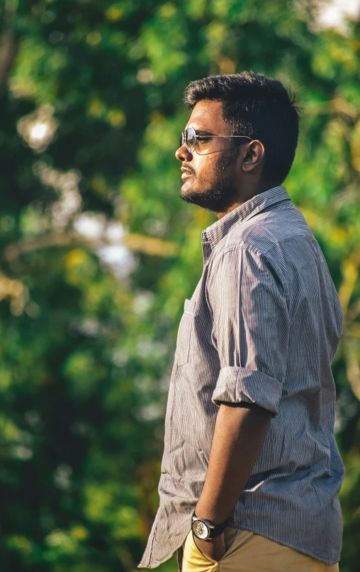 a man with his hands in his pocket looking off to the side