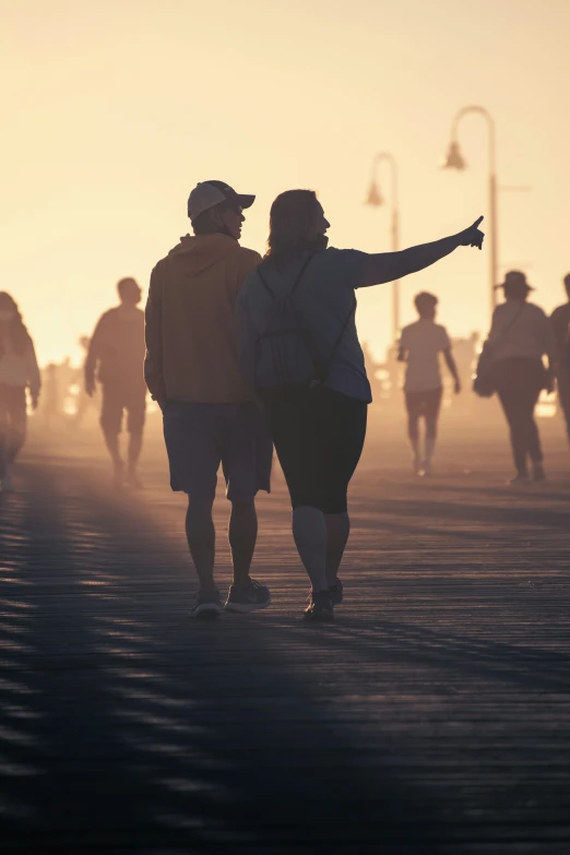 an image of two people walking on the beach