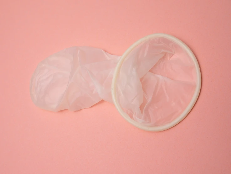 an oval and round object sitting on a pink surface