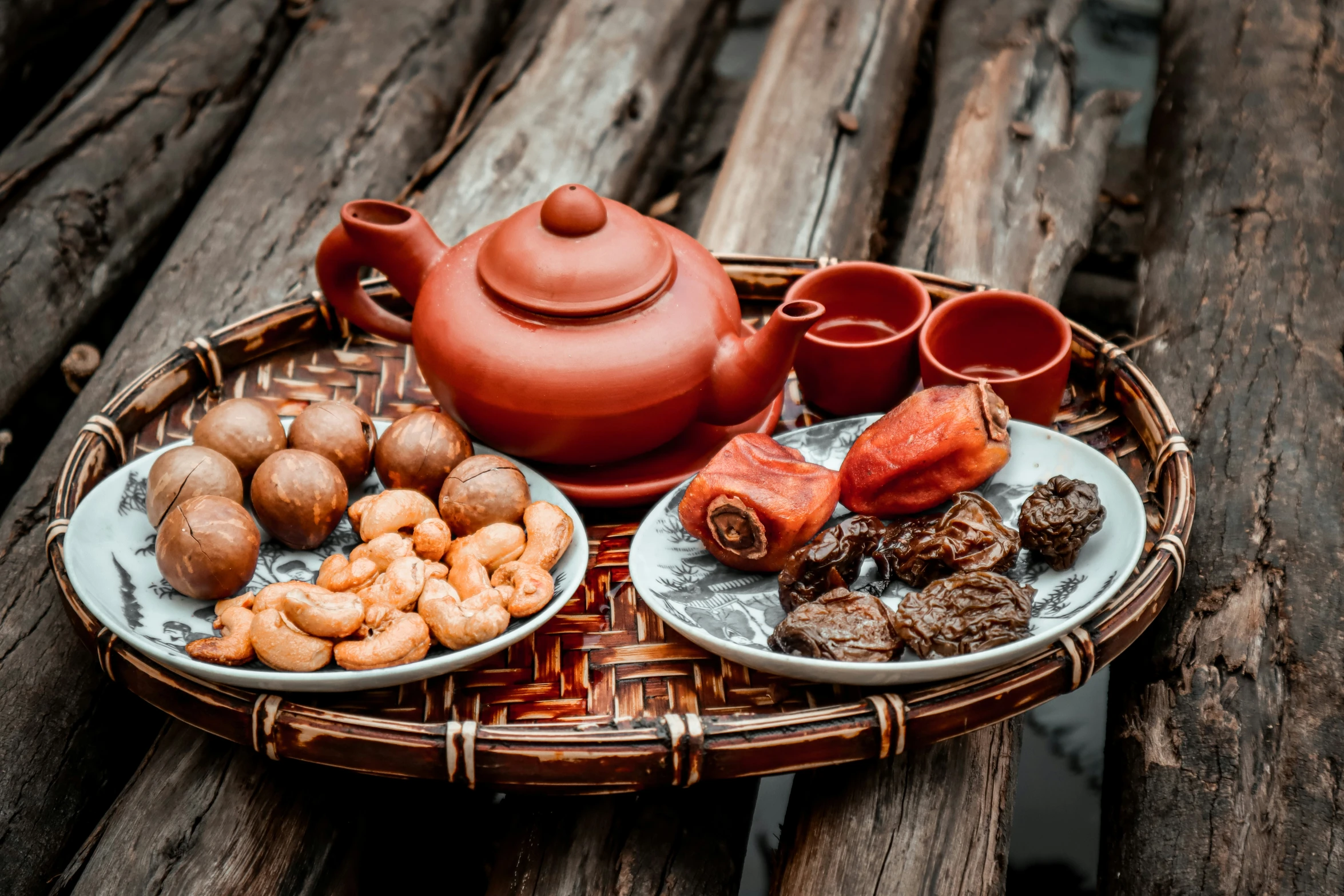 a basket with bowls, plates, mugs and a kettle on it