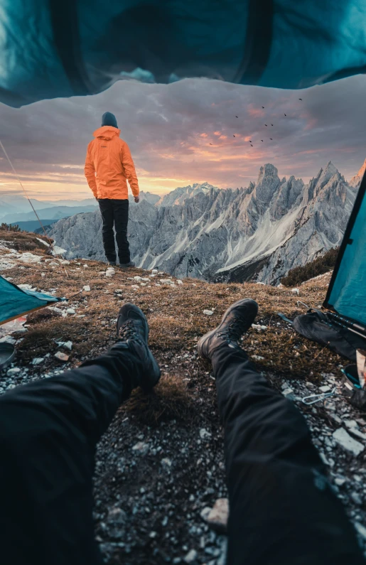 a man standing on top of a hill next to tents