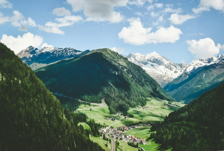 mountain range with green hillside under a partly cloudy sky