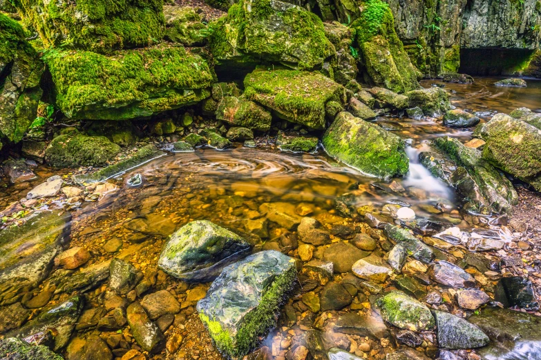 a stream flowing between rocks in the wilderness