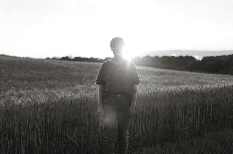 a person standing in a field near a mountain