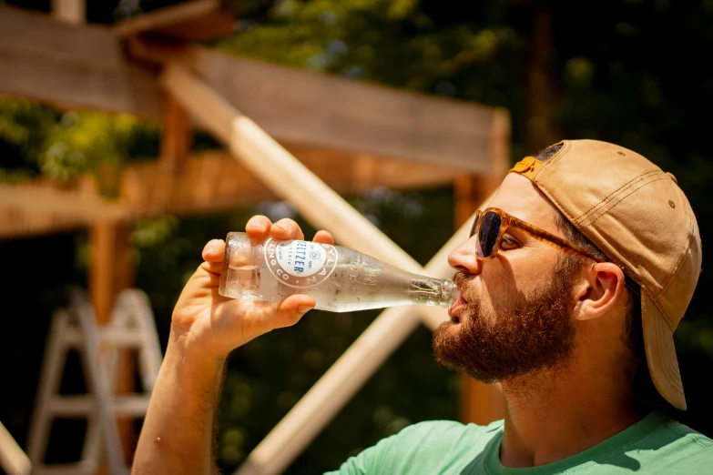 man drinking from a clear water bottle