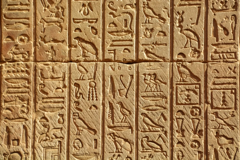 a wall in egyptian writing with egyptian symbols and hieroglyglyglyus on the side