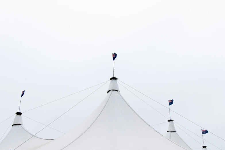 the top of a large white tent with a flag