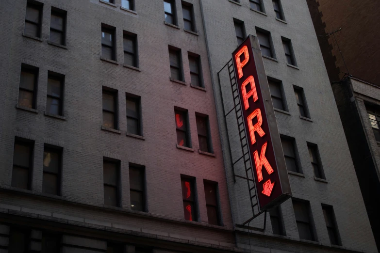 the side of an old building with a red light sign on it