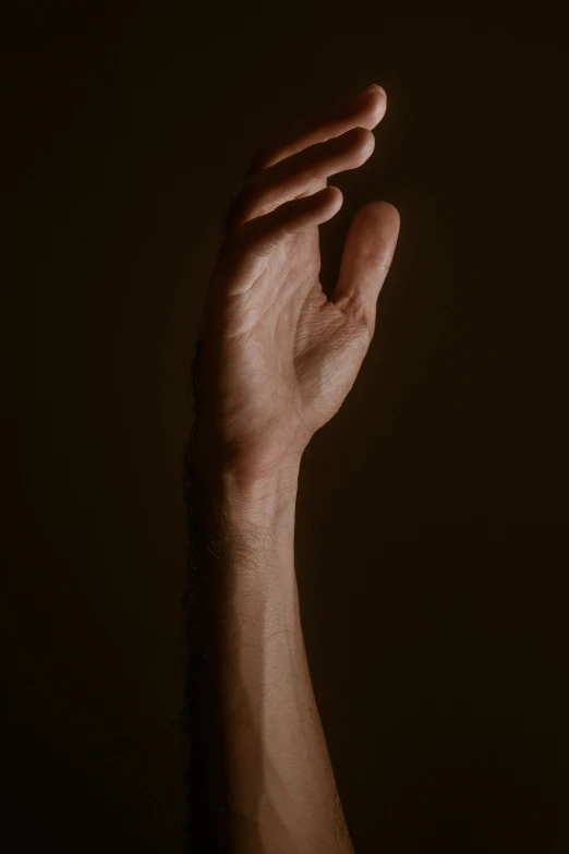 a person's hand is shown reaching up towards the dark sky