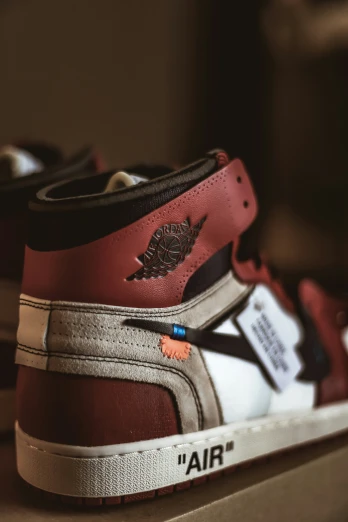 the red and white high top sneakers are on a brown shelf