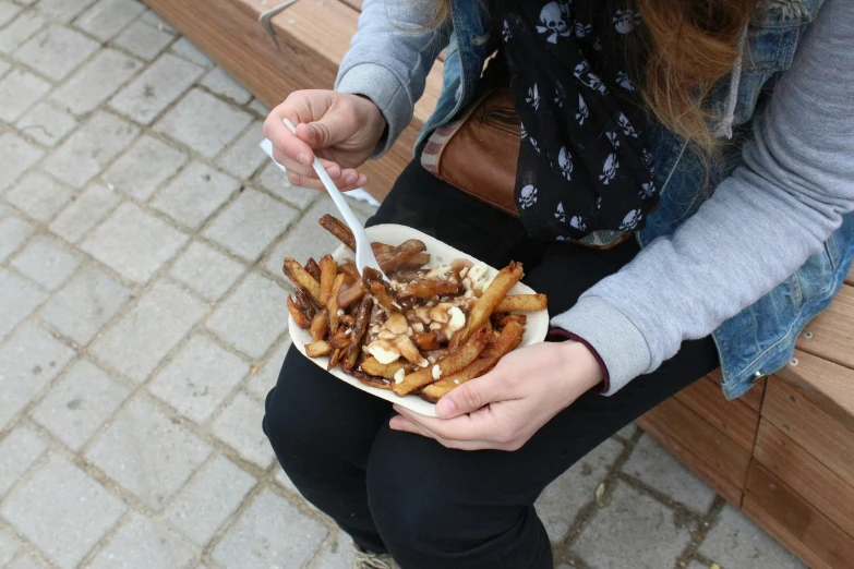 a person sitting on a bench with food