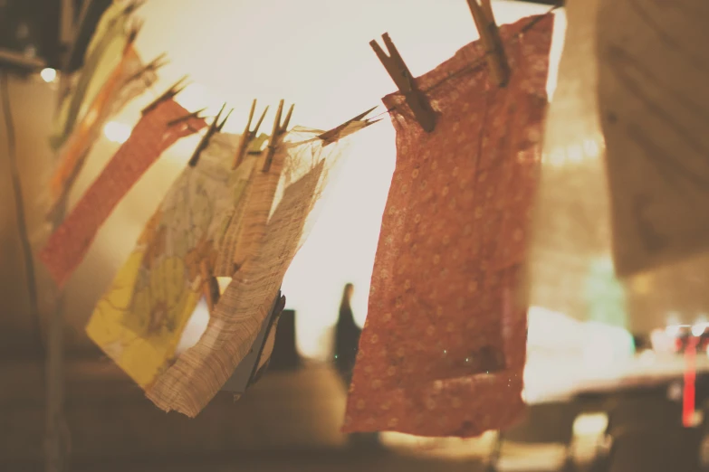 several clothes are hung on clothes pins near the building