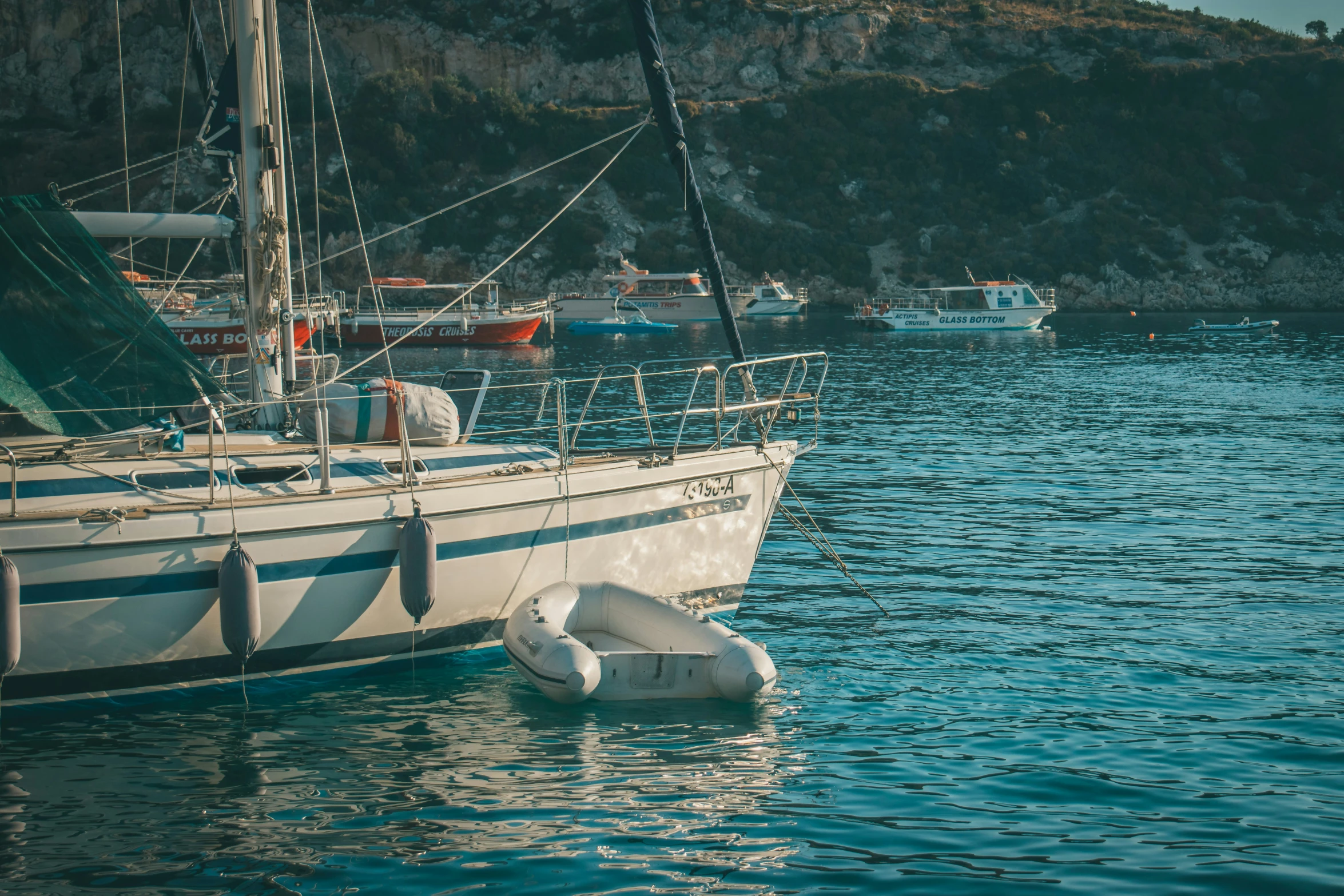 several boats docked in the water near mountains