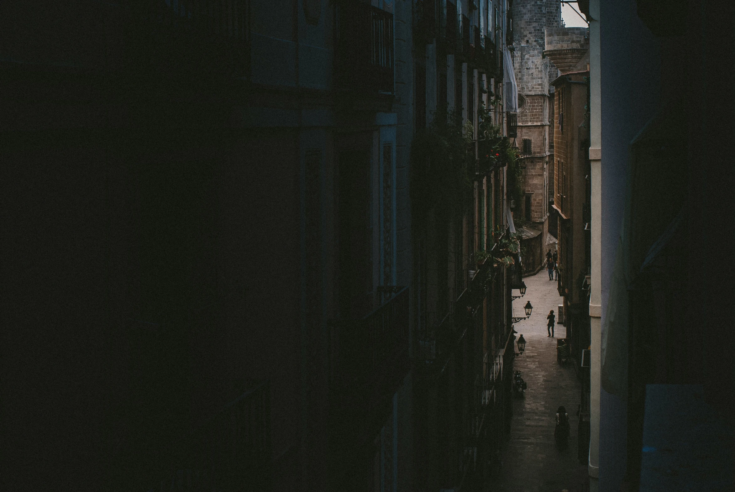 people walking down a street in a narrow alley way