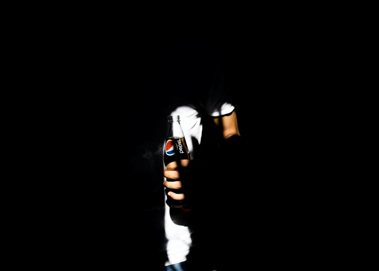 man in the dark holding beer in one hand