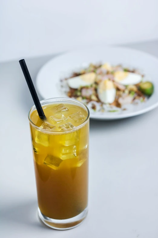 a cup filled with liquid next to a plate of food