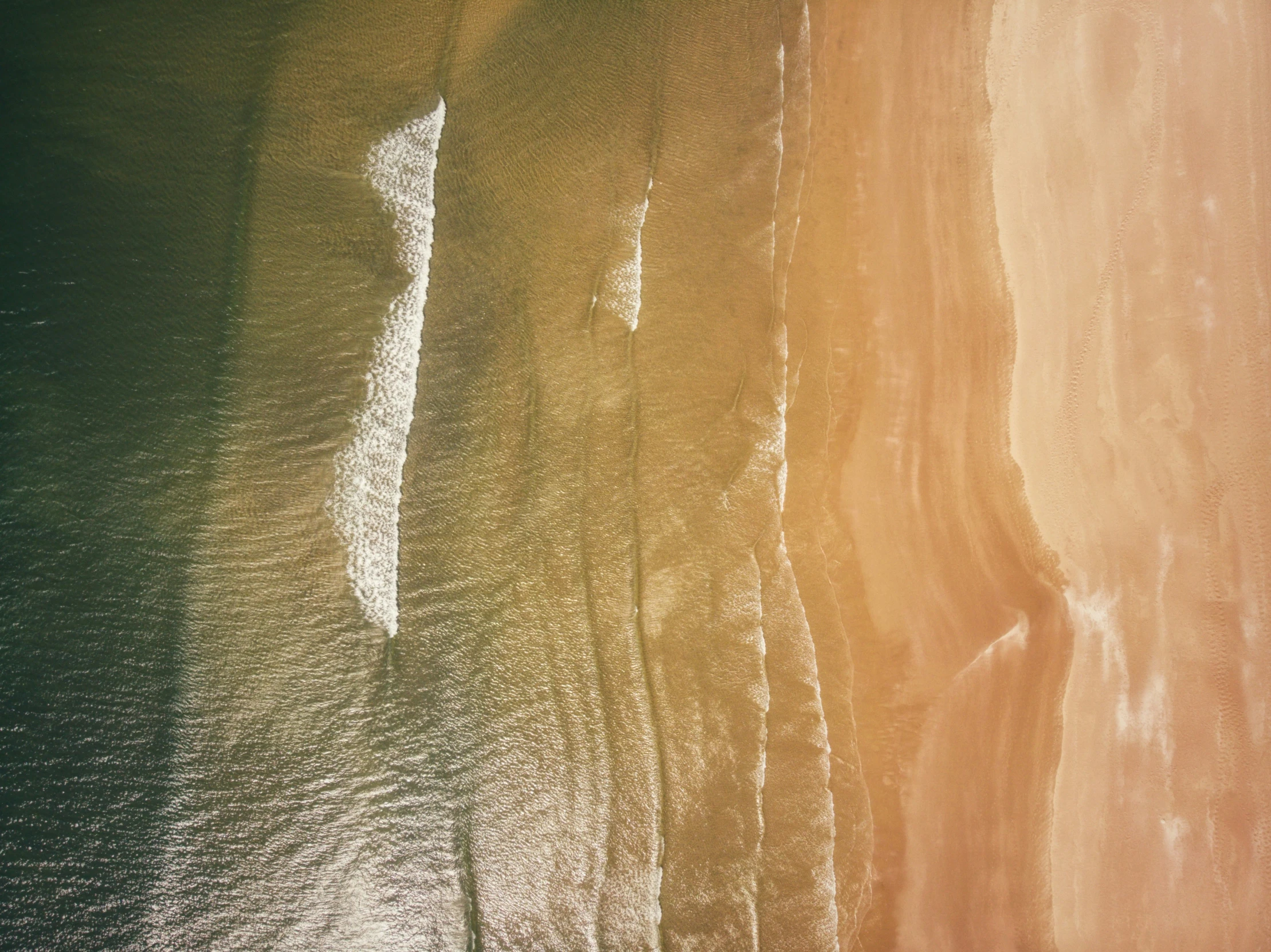 an overhead view of the ocean and beach