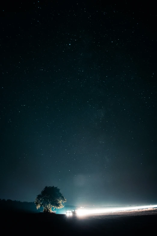 a vehicle is driving along the road under a nighttime sky