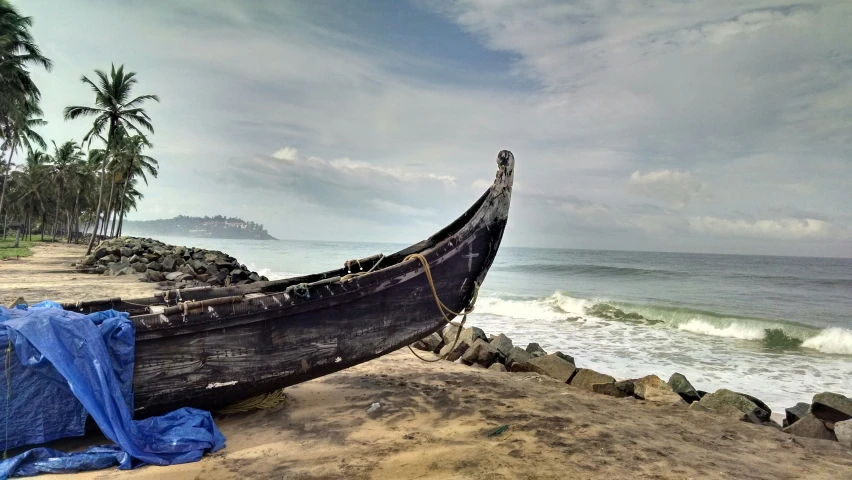 a boat in the sand next to an ocean