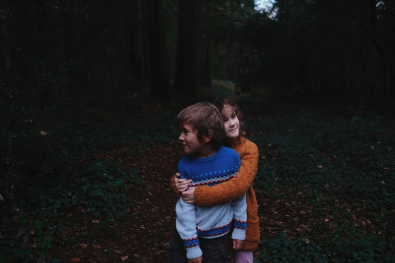 a little boy carrying his friend in the woods