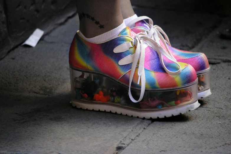 womans feet and colorful shoes standing on the pavement