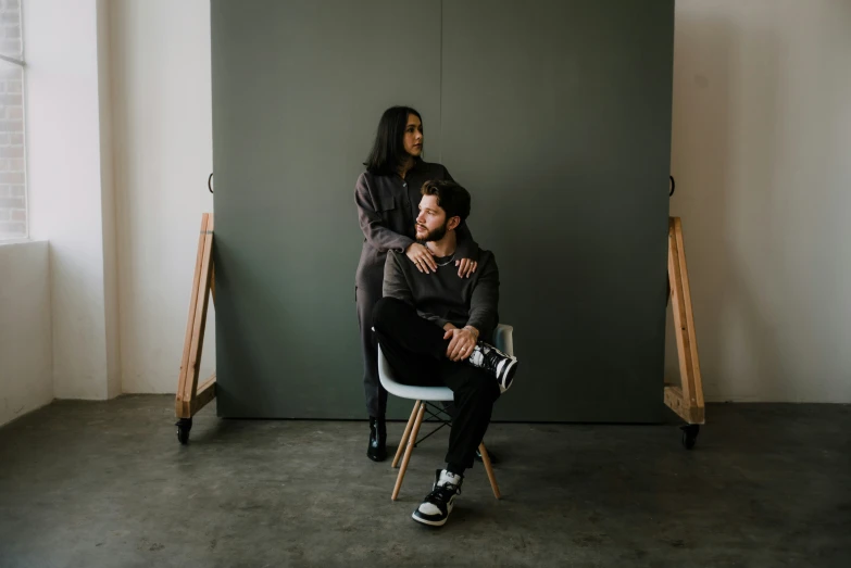 two young people are sitting down with one person emcing them