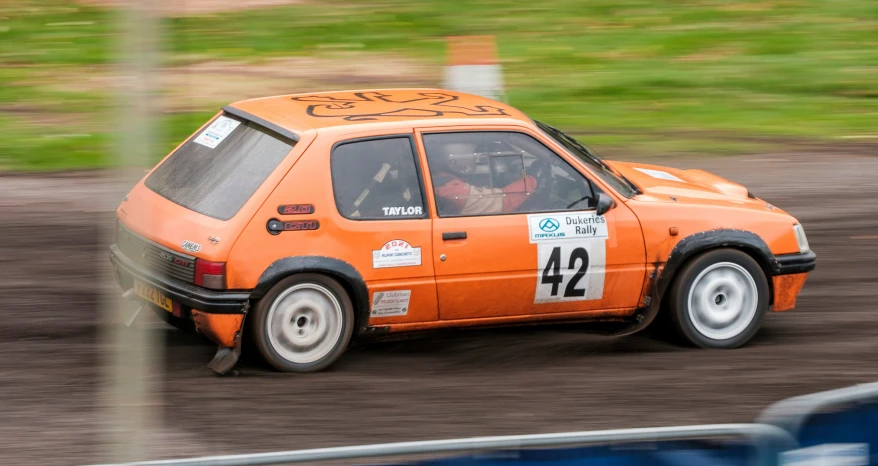 an orange race car driving on a track