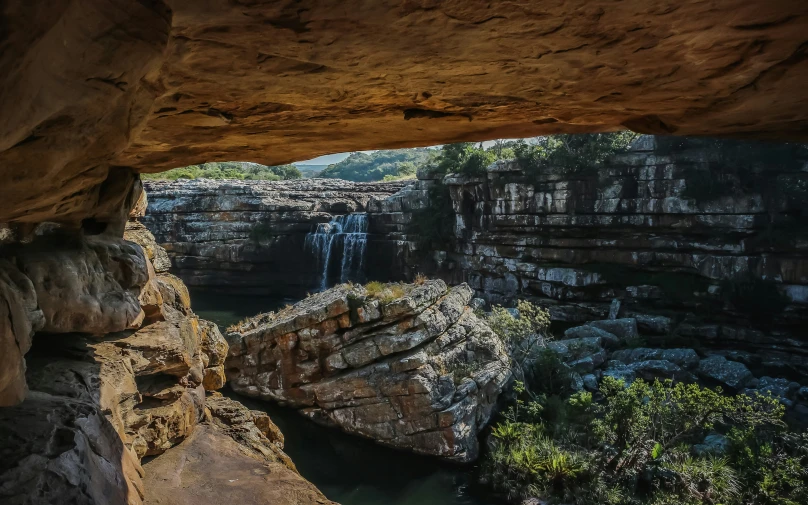 a view of a waterfall from inside a cave