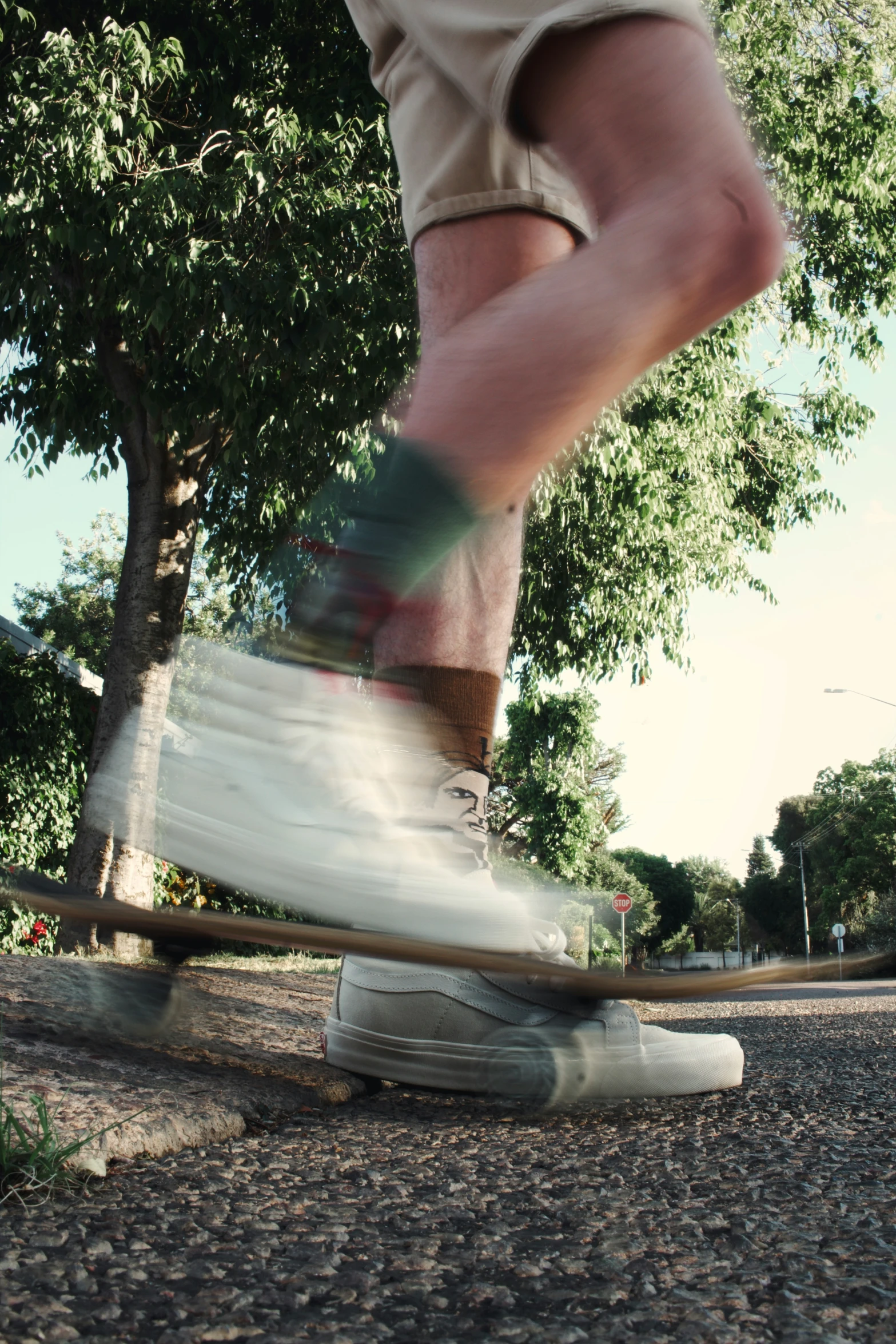 the feet of a skate boarder going around a pole