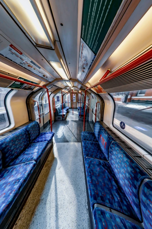 an empty train car is shown with long blue seats