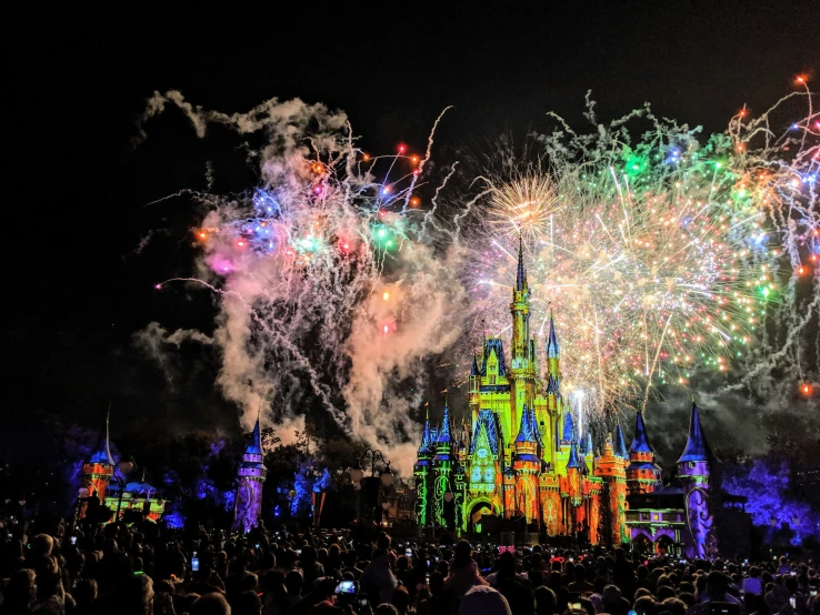 colorful fireworks and lights over a castle in the nighttime sky