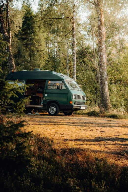 a vehicle is parked in a grassy area with trees in the background