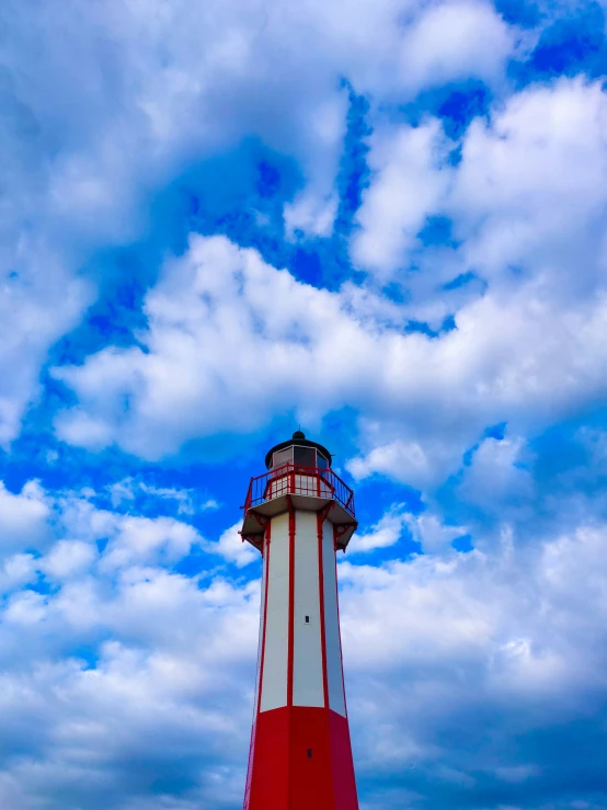a lighthouse in front of blue cloudy skies