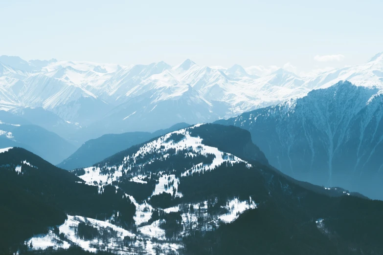 a large mountain covered in snow with mountains in the background