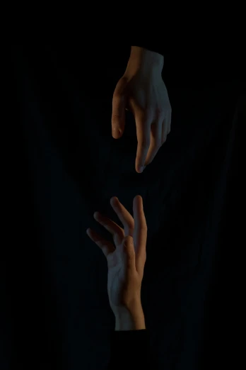 the dark, hands of someone reaching for soing