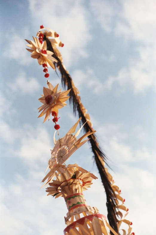 a long feather pole with decorative flowers and decorations on top