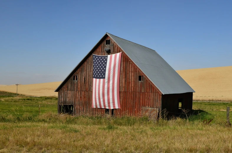 the old barn with the american flag on it